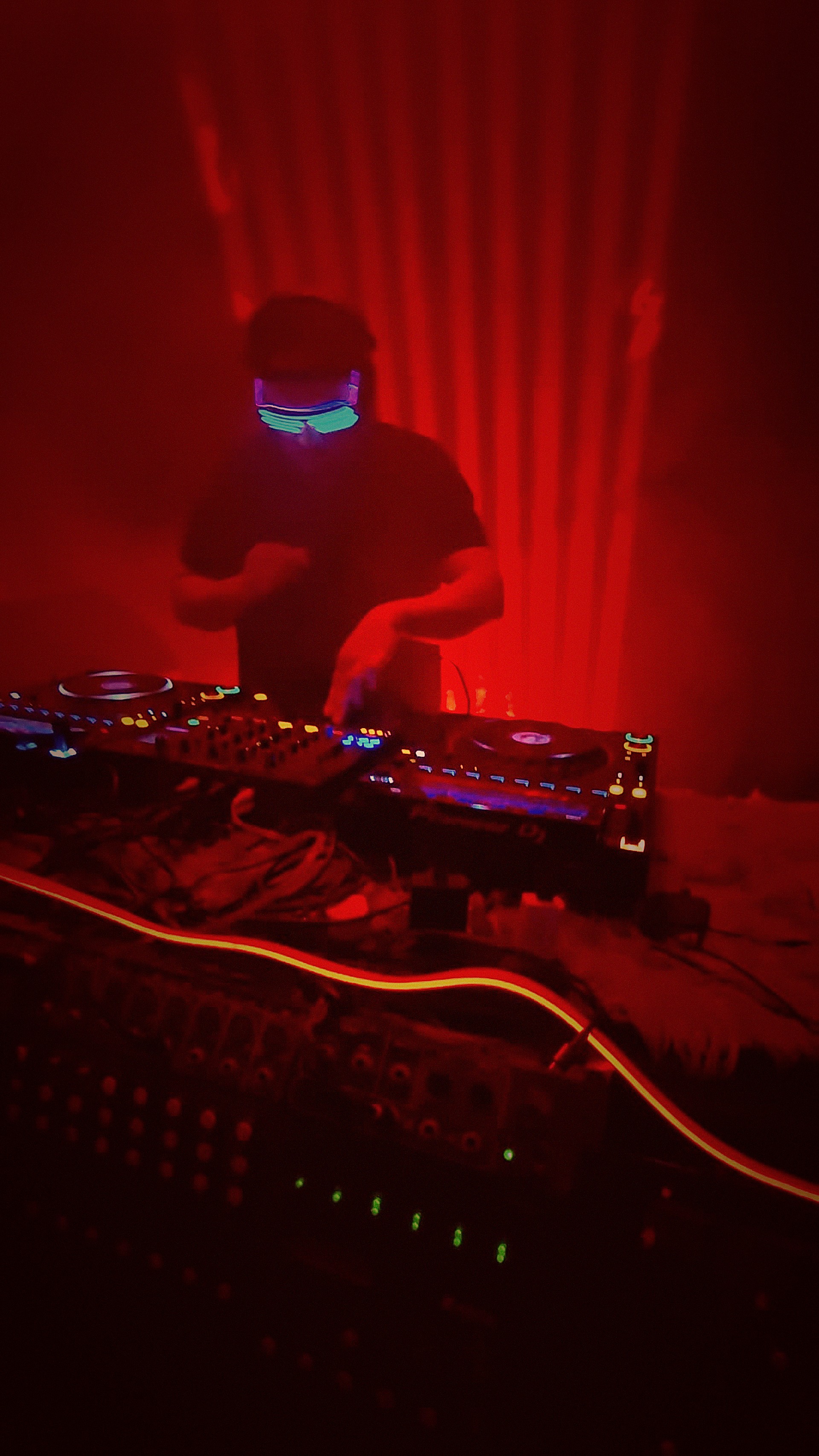 Meed / Syde wearing neon LED glasses behind the decks
